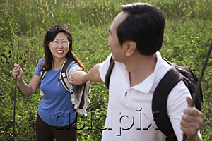 AsiaPix - Man and woman hiking outdoors, nature, holding hands, looking at each other