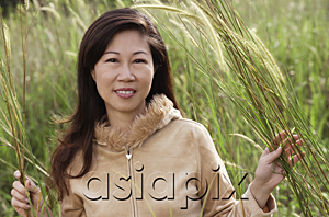 AsiaPix - Woman in tall grass, nature, looking at camera, smiling
