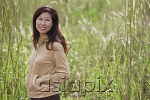 AsiaPix - woman standing in tall grass, nature, smiling at camera