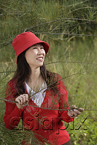 AsiaPix - Woman standing by tree, outdoors, nature