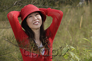AsiaPix - Woman wearing red hat outdoors in nature, smiling
