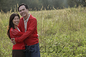 AsiaPix - Man and woman hugging each other, standing outdoors in nature, smiling