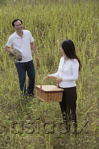 AsiaPix - Man and woman walking outdoors, carrying picnic basket and blanket