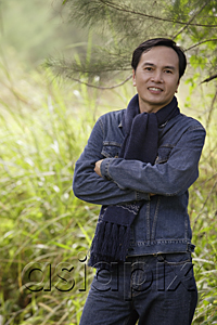 AsiaPix - Man wearing scarf, standing outdoors in nature, smiling at camera