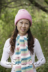 AsiaPix - Woman wearing hat and scarf outdoors in nature, smiling at camera