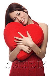 AsiaPix - Young woman hugging red heart shaped pillow