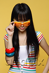 AsiaPix - Young woman peering over sunglasses