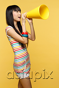 AsiaPix - Young woman shouting through yellow megaphone