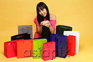 AsiaPix - Young woman surrounded by shopping bags, kneeling on floor