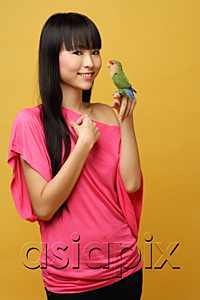 AsiaPix - Young woman holding lovebird on her hand