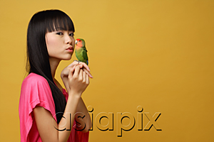 AsiaPix - Young woman with lovebird on her hand, kissing bird