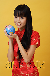 AsiaPix - Woman wearing cheongsam and holding globe in hands