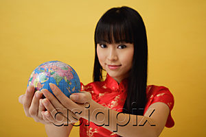 AsiaPix - Young woman wearing red cheongsam and holding globe in the palm of her hands