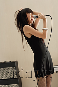 AsiaPix - Young woman singing into microphone