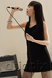 AsiaPix - Young woman singing into Microphone