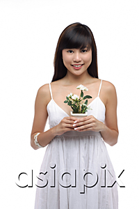 AsiaPix - Young woman wearing white dress and holing small plant