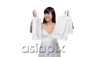 AsiaPix - Young woman wearing white dress and holding white shopping bags up in air