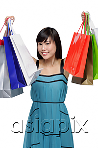 AsiaPix - Young woman wearing blue dress and holding shopping bags up in air