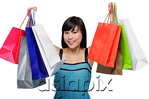 AsiaPix - Young woman wearing blue dress and holding colorful shopping bags up in air