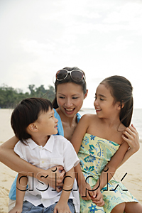 AsiaPix - Mother, daughter and son sitting on beach together