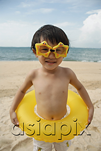 AsiaPix - Young boy on beach wearing yellow star goggles and holding yellow float around waist