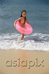 AsiaPix - Young girl on beach carrying pink float around waist