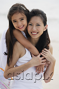 AsiaPix - Daughter behind mother with arms over shoulders, smiling, hugging, on the beach
