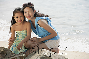 AsiaPix - Mother and daughter on beach by rocks