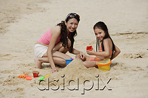 AsiaPix - Mother and daughter on beach, building sand castle