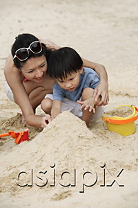 AsiaPix - Mother and son building sand castle on beach
