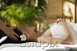 AsiaPix - Young woman receiving massage while laying on massage table, spa