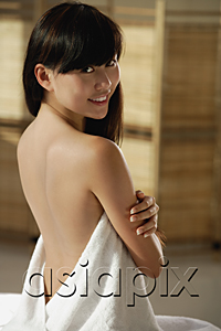 AsiaPix - Young woman wrapped in towel, back exposed, sitting on massage table