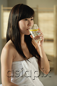 AsiaPix - Young woman wrapped in towel drinking lemon water