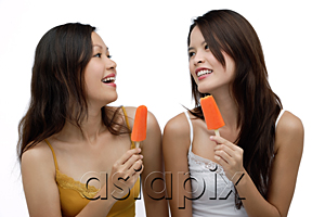 AsiaPix - Two young women eating Popsicle, smiling