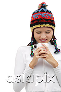 AsiaPix - Young woman wearing winter hat and staring down at mug of hot chocolate