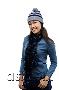 AsiaPix - Young woman wearing winter hat and scarf, smiling at camera