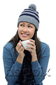 AsiaPix - Young woman wearing winter hat and scarf and holding cup