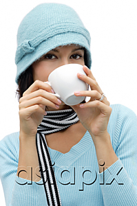 AsiaPix - Young woman wearing wool hat and scarf, drinking hot chocolate