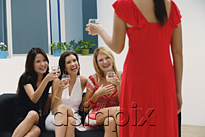 AsiaPix - Three women sitting on couch and toasting glasses to woman standing