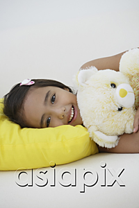 AsiaPix - A young girl lying down with her teddy bear