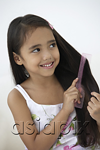 AsiaPix - A young girl combs her hair