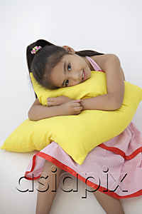AsiaPix - A young girl hugs a cushion