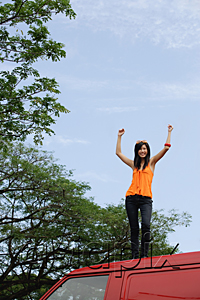 AsiaPix - A young woman dances on the top of a red van
