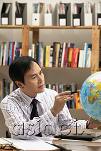 AsiaPix - A man working with a globe on the desk