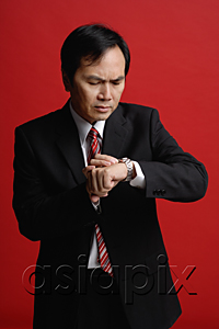 AsiaPix - A businessman checks his watch for the time