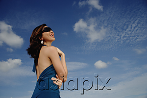 AsiaPix - A young woman with sunglasses stands with the sky in the background