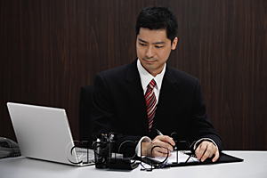 AsiaPix - A businessman in a suit sits at his desk