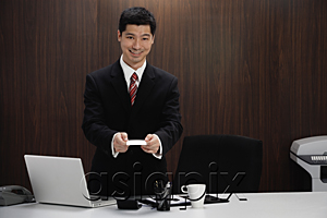 AsiaPix - A man in a suit holds out his business card
