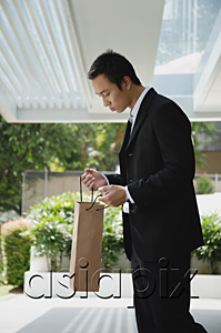 AsiaPix - A man looks in a bag while outdoors
