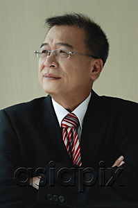 AsiaPix - A man with glasses and a suit folds his arms